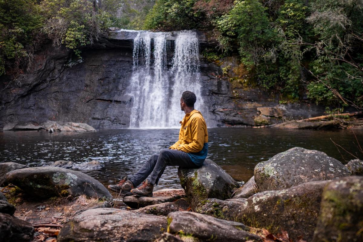Hiker sitting in front of Silver Run Falls waterfall