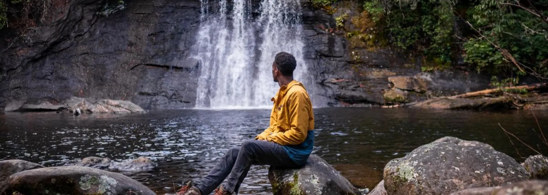 Hiker sitting in front of Silver Run Falls waterfall